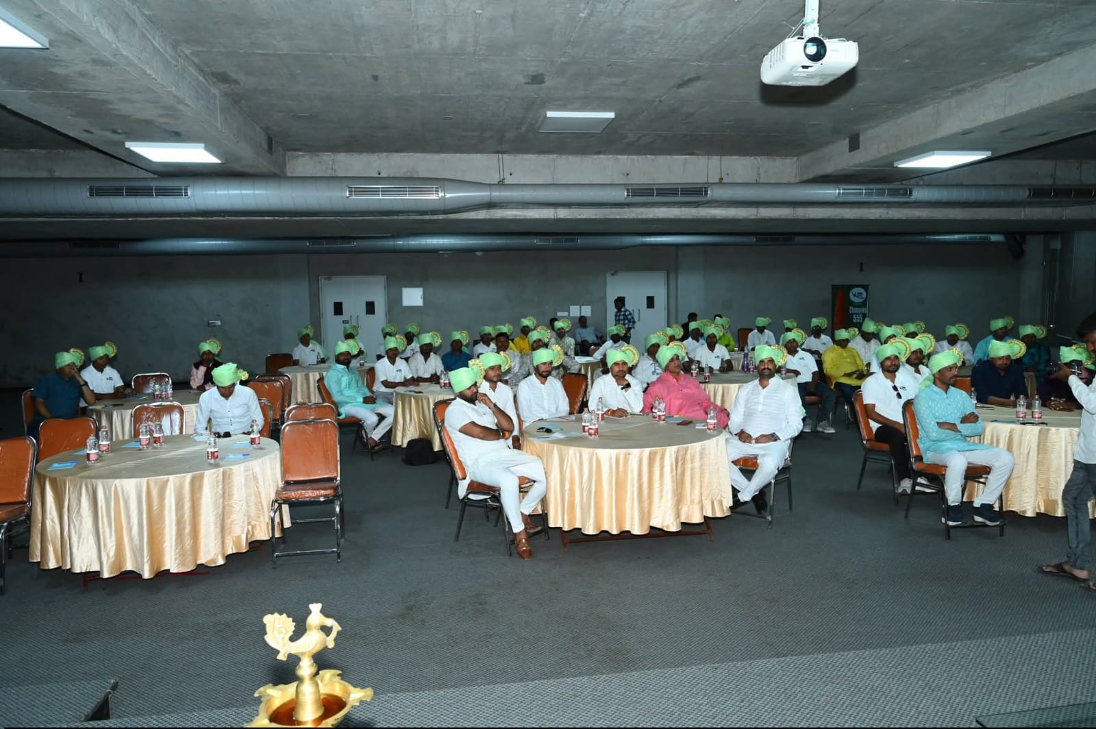 Farmer conference session with team members wearing green turbans
